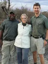 Here's a short alt tag for the image: Safari guides with tourist in Africa.