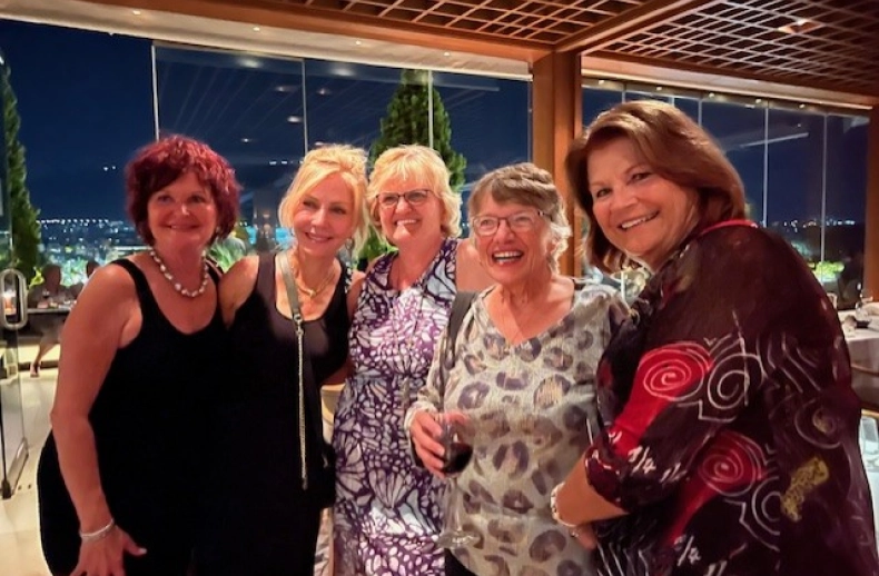 Five women friends at a rooftop party.