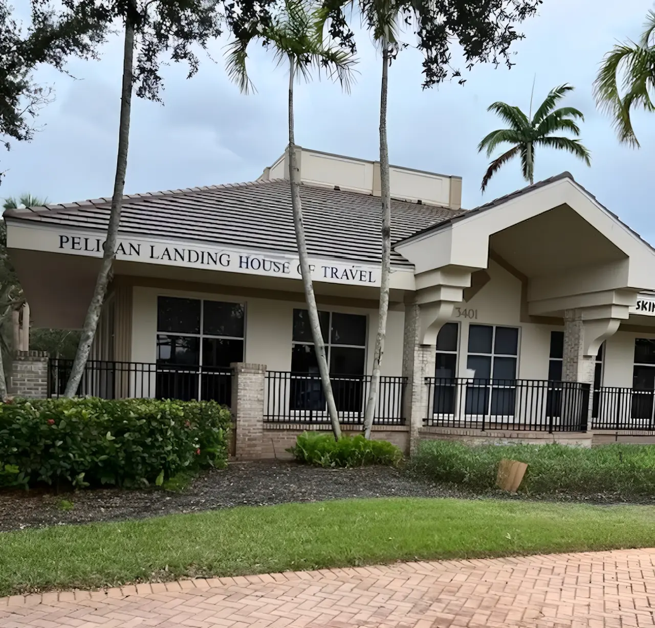 A building with palm trees in front of it.