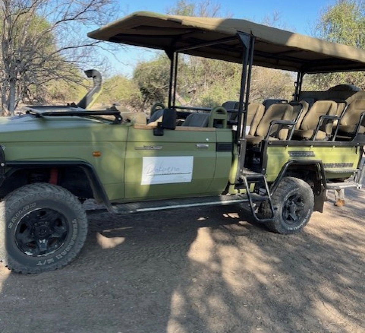 Safari vehicle, green, open-air seats.